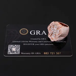 Detailed macro view of an iced out baguette moissanite ring with a GRA warranty card