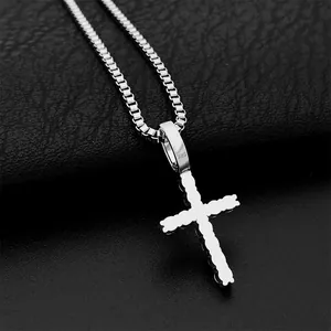 Nahaufnahme eines Kreuzanhängers aus 925er Sterlingsilber mit edlen Moissanit-Steinen.