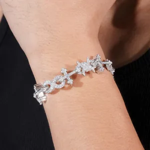 Detailed view of moissanite iced out bracelet with cross and infinity silver links