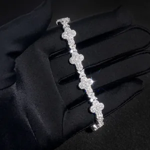 Gros plan d'un bracelet croix en moissanite montrant un éclat brillant sur gant noir