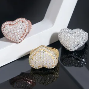 Detailed view of heart-shaped iced out rings in gold, rose gold and silver finish