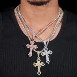 Détail de trois pendentifs croix hip-hop en or, argent et or rose étincelants