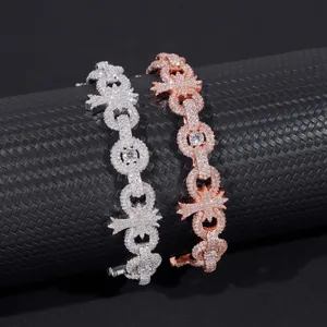 Detalle macro de pulseras cubanas de cruz de moissanita de 10mm en plata y oro rosa.