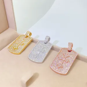 Close-up detail of iced-out moissanite dog tag pendants in gold and silver finishes