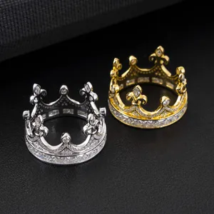 Detailed view of silver and gold moissanite crown rings on a black leather background