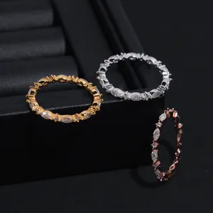 Vista detallada de tres anillos de eternidad de moissanita de corte marquesa en oro y plata.