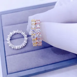 Primo piano di anelli eternity in moissanite rotonda da 4 mm in finiture oro e rosa.