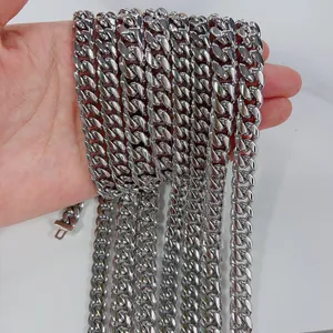 Detail view of 8mm and 10mm stainless steel Cuban link necklaces held to show scale