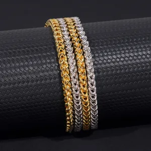 Gros plan sur des chaînes de blé de 4 mm en or et argent sur un support noir mat