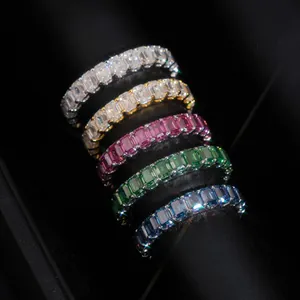 Macro view of five emerald cut moissanite eternity rings in white, pink, green and blue