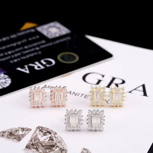 Vue macro de trois paires de boucles d'oreilles en moissanite taille émeraude, or et argent
