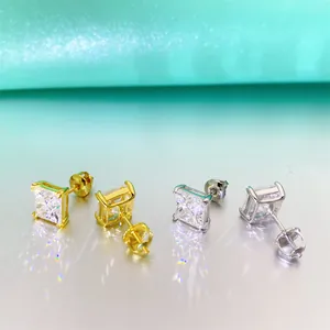 Détail macro de boucles d'oreilles en moissanite taille princesse, finitions or et argent