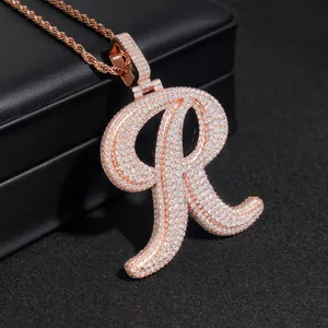 Macro view of iced-out rose gold letter R pendant with moissanite on a rope chain