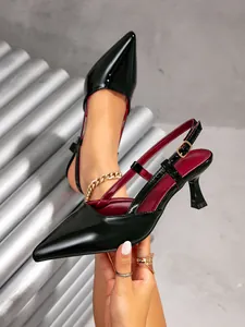 Dettaglio laterale di eleganti slingback nere a punta con fodera rossa