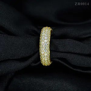 Macro de un anillo de plata chapado en oro con cuatro filas de piedras redondas.