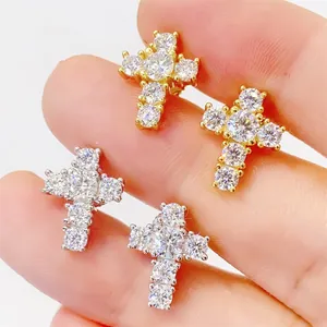 Détail de boucles d'oreilles en forme de croix avec moissanite, finitions or et argent