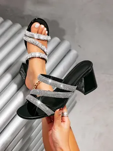 Close-up of black square-toe block heel sandals with shimmering rhinestone straps