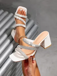Detailed view of elegant white square toe sandals featuring shimmering rhinestone straps