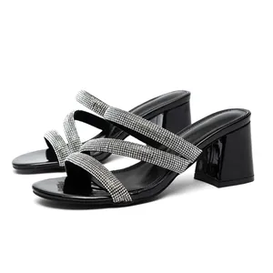 Elegant black block heel sandals with rhinestone straps and a modern square toe.