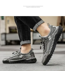 Vista dettagliata di sneakers in mesh grigio traspirante con suola cucita a mano da uomo