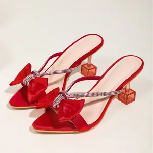 Eleganti sandali rossi con tacco alto, punta affusolata, fiocco e tacco in vetro.