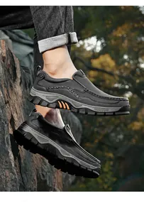 Detailed side view of durable men's outdoor slip-on leather loafers on rocky terrain