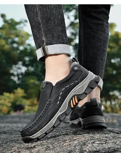 Close-up of men's black slip-on outdoor work shoes on rocky terrain outdoors.