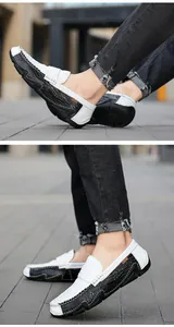 Close-up of men's black and white slip-on loafers with crocodile skin texture