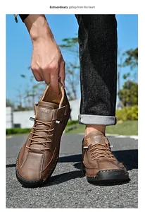 Front view of men's brown outdoor leather slip-on shoes on asphalt background