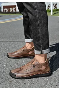 Detail view of brown leather outdoor work boots for men with hand-stitched soles