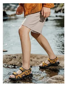 Detailed view of men's leather outdoor sandals worn while walking through a stream