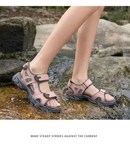 Close-up of durable pink leather outdoor sandals worn by a model in a stream.