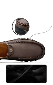 Macro detail shot of durable hand-stitched seams on brown leather outdoor loafers for men.