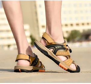 Detailed side view of men's khaki closed-toe beach sandals on a sunny sandy shore