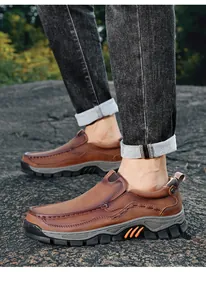Detailed side view of men's brown leather outdoor slip-on loafers on a rocky surface