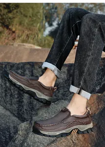 Close-up view of durable men's brown leather outdoor loafers on a rugged rocky path