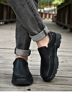 Gros plan de mocassins en cuir de vachette noir pour hommes sur un pont en bois
