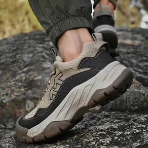 Detailaufnahme atmungsaktiver Herren-Wanderschuhe auf Felsen, Fokus auf die Sohlentextur.