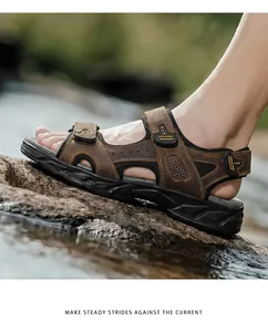 Detail of brown genuine leather men's outdoor sandal on a wet rock.