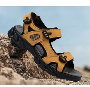 Detailed close-up of yellow genuine leather men's sandals on rocks under blue sky