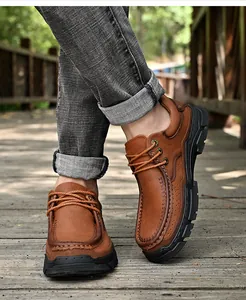 Gros plan de chaussures décontractées en cuir marron grainé sur une allée de parc en bois