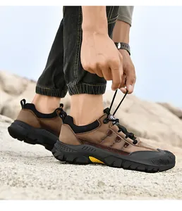 Primo piano di una scarpa da trekking marrone da uomo allacciata su terreni rocciosi