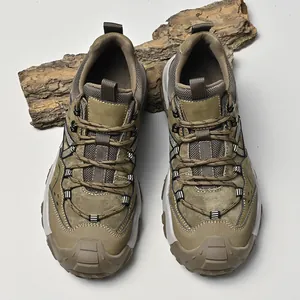 Detaillierte Draufsicht auf robuste olivgrüne Wanderschuhe auf Naturholzrinde Requisite.