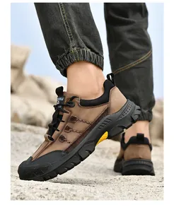 Vista dettagliata delle scarpe da trekking marroni da uomo su terreno roccioso all'aperto