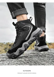 Primo piano di scarpe da trekking nere e grigie indossate su un terreno roccioso.