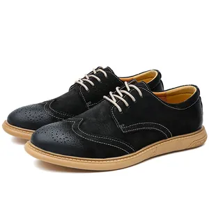 Detailed view of black suede brogue shoes with intricate perforated patterns and rubber soles.