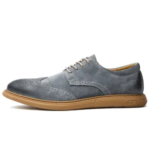 Side profile of a stylish grey suede Brogue shoe for men featuring a tan rubber sole