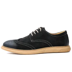 Side view detail of a black suede wingtip Brogue shoe with tan rubber sole.