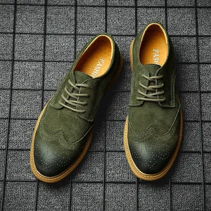 Macro top view of men's green suede wingtip brogue shoes with classic perforations