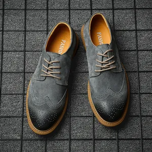 Top-down view of grey gradient men's leather Brogue shoes on a modern grid backdrop